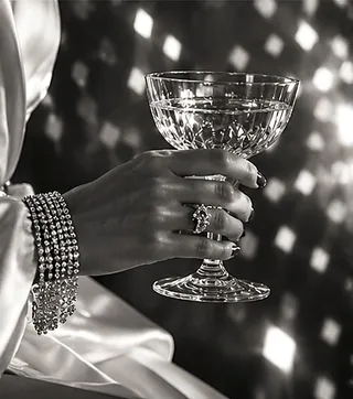 Braut mit Ehering hält eine Champagnerschale, Audio Gästebuch für die Hochzeit anfragen